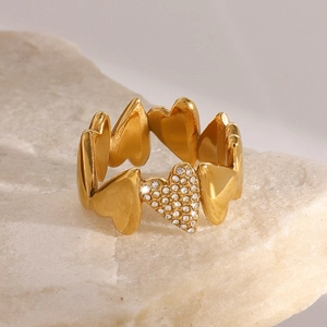 Detail of 18k gold plated heart ring with sparkling zircon stones on natural stone