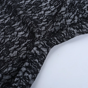 Gros plan sur la dentelle noire avec motifs de roses et texture en maille délicate