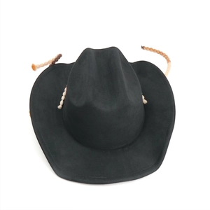 Détail d'un chapeau de cowboy en suédine noire avec ruban perlé tribal et calotte pincée