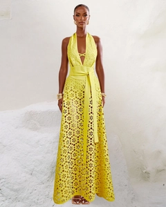 Detailed view of yellow hollow-out embroidery and waist tie on an elegant maxi dress