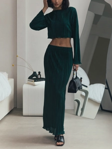 Macro detail of dark green pleated fabric showing fine texture of two-piece skirt set