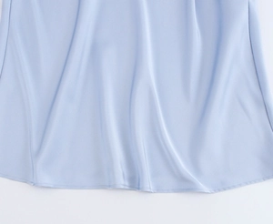 Close-up of light blue satin dress hem showcasing silky texture and fine stitching