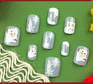 Detail showing Christmas press-on nails with snowman, snowflakes and silver glitter