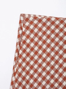 Detailed view of the red and white checkered skirt waist seam and stitching quality