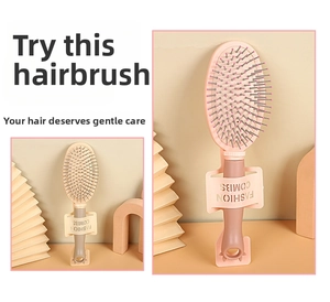 Detail of ergonomic hairbrush handle with hanging hole and rounded massage bristle tips