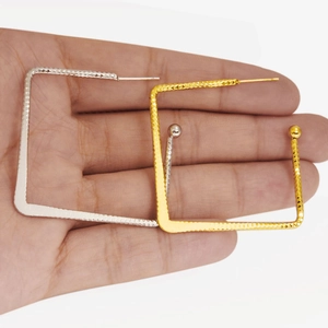 Detail of square textured hoop earrings in gold and silver finish shown for size reference
