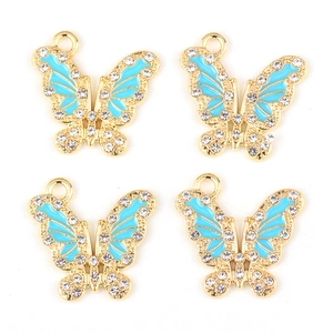 Detailed view of sky blue enamel butterfly charms with gold base and white rhinestones