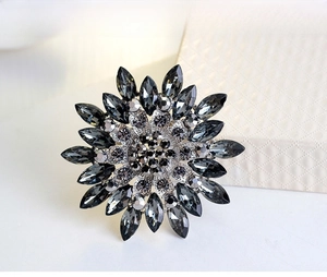 Macro detail of sunflower brooch with grey marquise crystals and silver metal setting