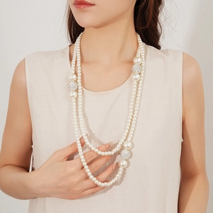 Close-up of double-layered pearl necklace featuring sparkling diamond-encrusted spheres
