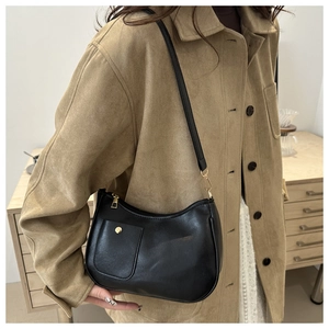 Close-up of black PU leather crescent shoulder bag with golden round buckle pocket