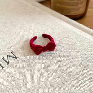 Macro detail of dark red velvet flocking on the bow-shaped adjustable open ring