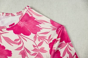 Détail de l'encolure ronde et de la couture d'épaule sur robe longue fleurie rose