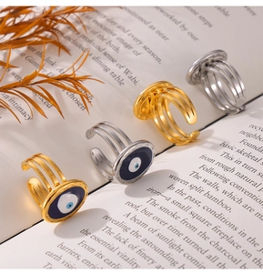 Detailed view of adjustable evil eye rings in gold and silver on a vintage book page