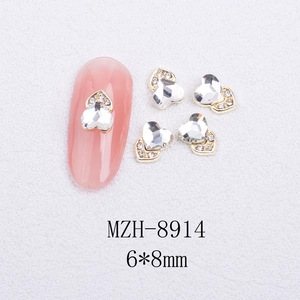 Detail view of 6x8mm heart-shaped cat eye nail charms with gold base and white zircon