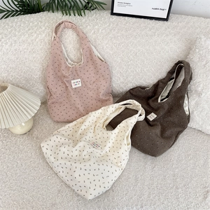 Détail du sac cabas vintage en velours côtelé à fleurs avec étiquette de marque