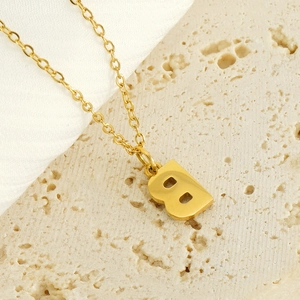 Minimalist golden stainless steel letter B necklace with rhinestones on a satin background