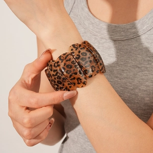 Détail des maillons ovales à motif léopard sur un large bracelet en résine