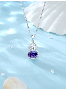 Macro shot of S925 silver gourd pendant with purple gemstone and white zircon on silk