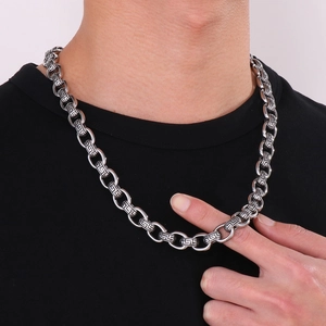 Detailed close-up of a men's vintage silver necklace featuring geometric Greek key patterns