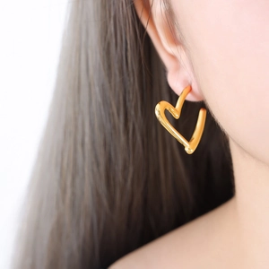 Minimalist 18k gold plated stainless steel heart hoop earrings worn by a model