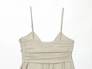 Detailed close-up of champagne silk fabric with elegant pleated bust and adjustable straps
