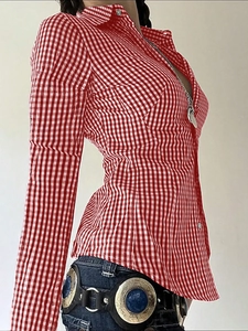 Side view of red plaid long sleeve shirt with collar and metal buckle belt on model