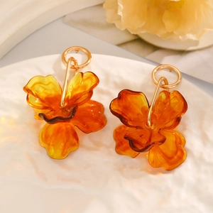Detailed close-up of amber flower petals and golden hoop on summer raffia earrings