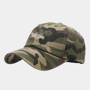Détail de la casquette camouflage montrant la broderie blanche et la visière courbée