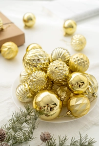 Boules de Noël dorées avec textures mates, brillantes et facettées en décor festif