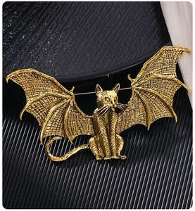 Detailed macro view of the vintage gold winged cat brooch showing retro engraved texture