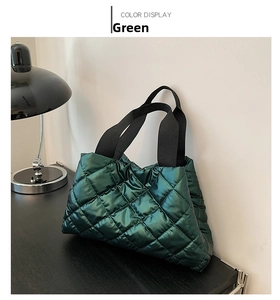 Détail du sac fourre-tout matelassé vert foncé en tissu bouffant et sangle noire