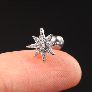 Macro shot of silver star-shaped earring with clear zircons on the upper ear cartilage