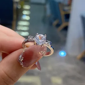Close-up of a silver ring with a large round cubic zirconia and bow details