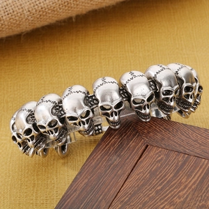 Detail of vintage silver skull bracelet with gothic engraving and retro distressed finish