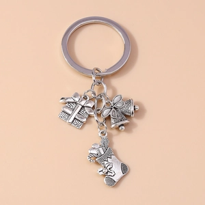 Detailed close-up of vintage silver Christmas charms including gift box, bell, and stocking