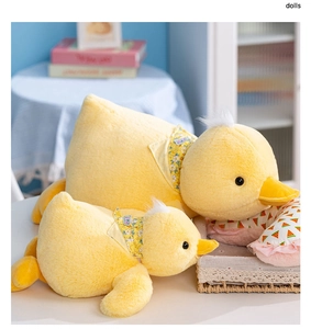 Close-up of small and large plush yellow ducks with floral scarves on a blue background