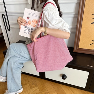 Detail einer rot-weiß gestreiften Canvas-Tasche mit roter Kante und Stickerei-Akzenten