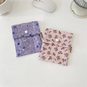 Detail of floral sanitary bag with ruffle texture, snap button and woven brand label