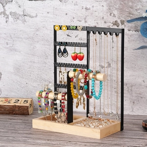 Multifunctional jewelry organizer with black metal frame and wooden base on table