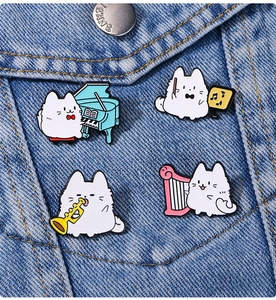 Detailed view of four cute musical cartoon pins on denim fabric showing instruments