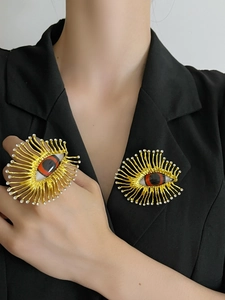 Detail of vintage evil eye ring and brooch set with gold finish and white crystals