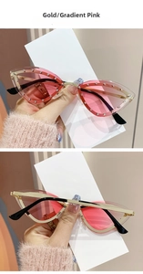 Détail de lunettes de soleil œil de chat, monture dorée, verres dégradés roses et strass