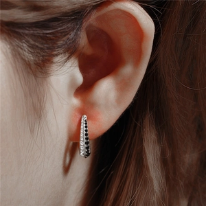 Close-up of classic S925 silver huggie earrings with double row black and white crystals