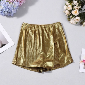 Detailed close-up of metallic gold pleated skirt with shiny texture and floral accents