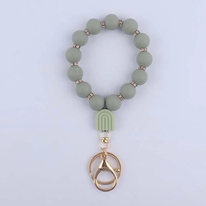 Detail of grey-green silicone beaded keychain with rhinestone spacers and golden metal clasp