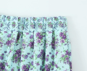 Detailed macro view of the elastic waistband and floral print on this blue casual skirt