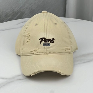 Detailed view of khaki distressed baseball cap featuring Paris 1976 vintage embroidery