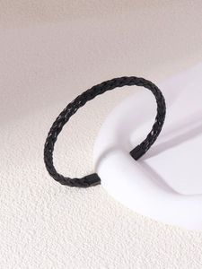 Detailed macro shot of the black woven texture on the stainless steel cuff bracelet