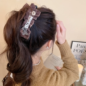 Pince à cheveux à carreaux marrons avec nœud et bouton vintage sur un mannequin