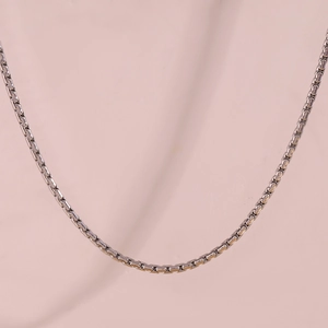 Close-up of a silver stainless steel box chain necklace with smooth metallic texture